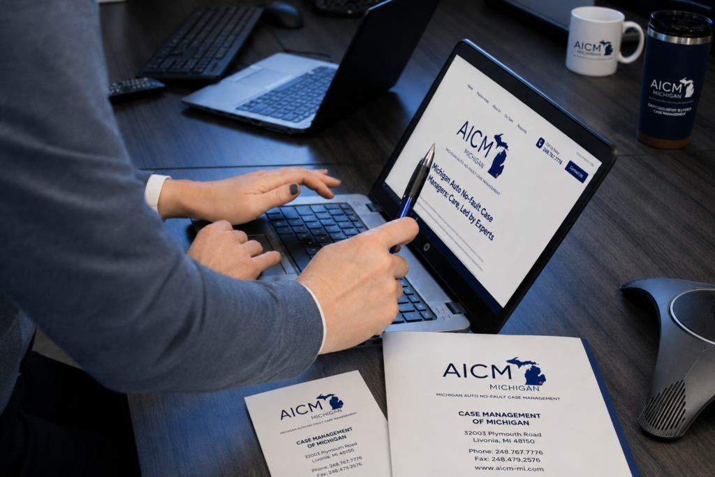 AICM – Michigan case management professional reviewing the AICM website, with branded materials displaying the Livonia, Michigan office information.